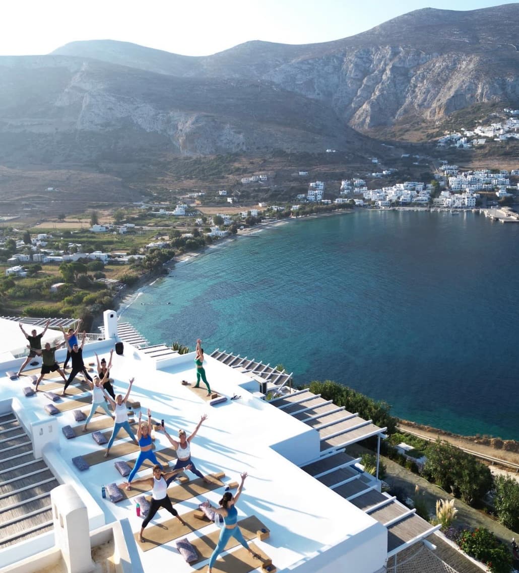 Guests practicing morning rooftop yoga overlooking the coast at a True North retreat