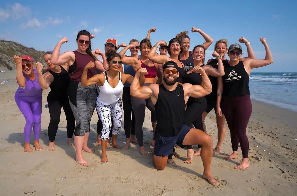 True North Retreats guest cohort gathered on the beach after a coastal excursion